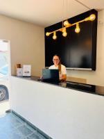 una mujer sentada en un mostrador con un portátil en Art Hotel, en Mogi Guaçu