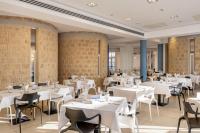 Simeri MareVOI Floriana Resort的摆放着白色桌椅的餐厅