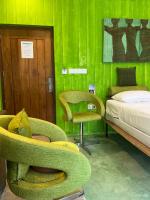 a room with a green wall with a bed and chairs at Dickman Resort "The Boutique Hotel" in Negombo