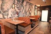a restaurant with tables and chairs and a floral wall at EGINO-Premium Hotel, Restaurant & Bar in Eggenburg