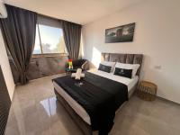 Un dormitorio con una cama grande y una ventana. en Elis Boutique Hotel, en Bat Yam