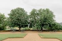 two trees with tables and chairs in a park at Château de Pierreclos in Pierreclos