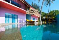 a swimming pool with an umbrella next to a building at Dickman Resort "The Boutique Hotel" in Negombo