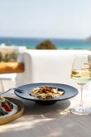 a plate of food and a glass of wine on a table at Mileo in Kalo Livadi