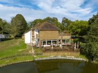 ein Haus auf einem Wasserkörper in der Unterkunft Hôtel et Cottages Domaine Du Marquenterre in Saint-Quentin-en-Tourmont