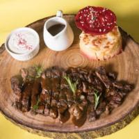 a wooden cutting board with a plate of food and a donut and a cup at Khabti Grand Hotel in Qal'at Bishah