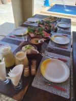 ein Tisch mit Tellern voller Speisen und Getränken in der Unterkunft Pousada Alto do Tambá in São Francisco