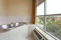 ein Badezimmer mit Waschbecken und großem Fenster in der Unterkunft Days Inn &amp; Suites by Wyndham Milwaukee in Milwaukee