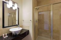 ein Badezimmer mit Waschbecken und Dusche in der Unterkunft Days Inn &amp; Suites by Wyndham Milwaukee in Milwaukee