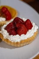 Un postre con crema batida y fresas en un plato. en HOTEL CITY, en Posadas