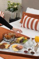 bandeja de alimentos para el desayuno en una cama en Hôtel La Truffe Noire, en Brive-la-Gaillarde