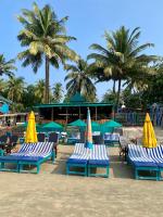 un grupo de sillas de playa con sombrillas y palmeras en Chill Out Jasmine Restaurant Bar Rooms, en Palolem