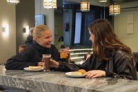 two women sitting at a table with plates of food at Gspot Hostels & Love Triangles Pizzeria in Lisbon