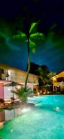 a palm tree sitting next to a swimming pool at night at Dickman Resort "The Boutique Hotel" in Negombo