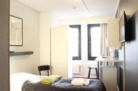 a bedroom with a bed and a table with chairs at Forenom Aparthotel Lahti in Lahti