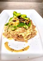 Un plato de pasta con brócoli encima. en Coto Island Beach Village Homestay, en Dao Co To