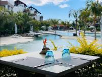a table with utensils on it next to a pool at Luxury Penthouse with Jacuzzi, 2 min to Beach in Mont Choisy