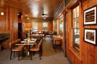 een restaurant met houten wanden en tafels en stoelen bij LOGE Glacier in Essex