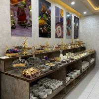 una línea de buffet con platos y comida a la vista en Ohu Palace, en Ferganá