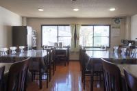 een eetkamer met tafels en stoelen en een groot raam bij lodge EDMONTON in Yuzawa