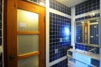a blue tiled bathroom with a door and a mirror at Full Sweet Inn in Wujie