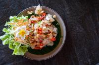 a plate of food with a salad on a table at Lanta Riviera Beach Resort in Ko Lanta