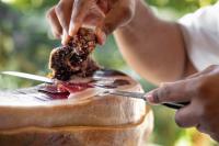 una persona cortando un trozo de comida con cuchillo y tenedor en Aparthotel Solifemar, en Castelldefels