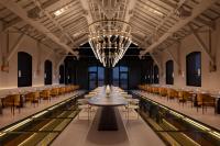 um grande salão com mesas, cadeiras e um lustre em The Chedi Hegra, AlUla em Al Ula