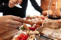 una persona sosteniendo un trozo de comida junto a una copa de vino en Hotel Al Bivio - Pizzeria, Pool & Sauna, en Imer