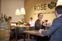 een vrouw aan een tafel met een glas wijn bij Biohotel-Restaurant Rose in Hayingen