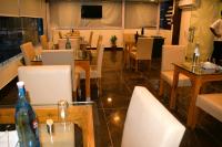 een restaurant met witte stoelen en tafels en een televisie bij Hotel Shreya Galaxy with Swimming Pool- Best Property in Haridwar in Haridwār