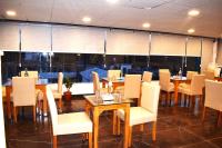 een eetkamer met tafels en witte stoelen bij Hotel Shreya Galaxy with Swimming Pool- Best Property in Haridwar in Haridwār