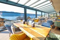 瑟尔尼察Lavalliere Hotel & Villas的一家餐厅，里面摆放着木桌椅和一扇大窗户。