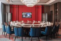 水城六盘水星俪岚酒店的一间带大桌子和蓝色椅子的用餐室