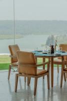 a dining table with two chairs and a table with a view at Araqila Boutique Beach Resort near MOPA airport in Vengurla