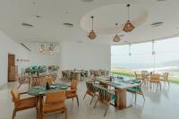 a restaurant with tables and chairs and a large window at Araqila Boutique Beach Resort near MOPA airport in Vengurla