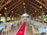 una sala per banchetti con tavoli e sedie bianchi di Hizo Garden Resort a Buôn Du Enguôl