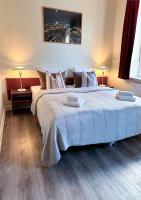 1 cama grande en un dormitorio con 2 lámparas en Hotel Frederikshavn, en Frederikshavn