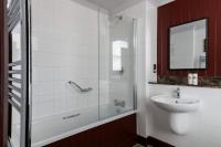 a bathroom with a tub and a sink and a mirror at The Brewers Inn in London