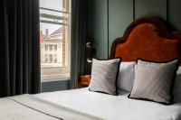 a bed with two pillows sitting next to a window at The Brewers Inn in London
