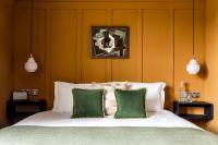 a bedroom with a bed with two green pillows at The Brewers Inn in London
