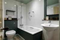 a bathroom with a tub and a sink and a toilet at The Brewers Inn in London