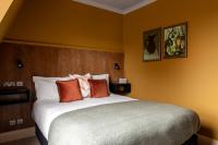 a bedroom with a large bed with orange walls at The Brewers Inn in London