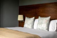 a bed with two pillows and a wooden headboard at The Brewers Inn in London