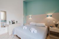 Un dormitorio con una cama con toallas blancas. en Il Melo Residence, en Porto Torres