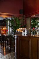 a bar in a restaurant with a table and plants at The Brewers Inn in London