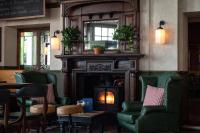 a bar with green chairs and a fireplace at The Brewers Inn in London