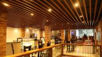 a restaurant with a wooden ceiling and tables and chairs at Heritage Grand - Badulla in Badulla