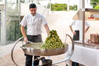a man is preparing a bunch of bananas in a pot at VOI Alimini Resort in Alimini