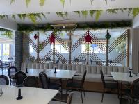 Un restaurante con mesas y sillas y un gran ventanal. en Sun on the bay beach hotel, en Palmar de Ocoa